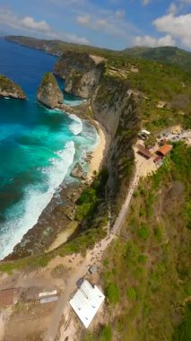 Endonezya, Bali 'deki Nusa Penida Adası' ndaki Elmas Sahili 'nin dramatik uçurumları ve turkuaz suları üzerinde dinamik FPV insansız uçuşu. Kireçtaşı oluşumlarının ve okyanus dalgalarının doğal güzelliklerini yakalar..