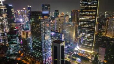 Yoğun trafik, aydınlık gökdelenler ve şehrin ufuk çizgisi olan Jakarta iş bölgesinin gece hava zaman çizelgesi. Şehir, iş, seyahat ve altyapı temaları için ideal.