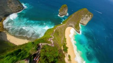 Dramatik uçurumlar, beyaz kum plajları ve Endonezya 'nın Nusa Penida kentindeki Kelingking Sahili' ndeki turkuaz okyanus üzerinde FPV insansız hava aracı uçuşu. Seyahat, yaz ve tropikal macera temaları için ideal.