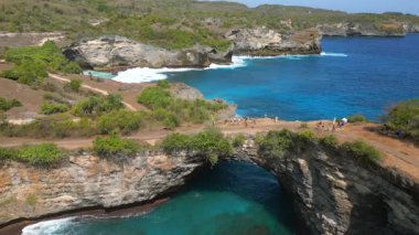 Bali 'de Nusa Penida' daki Broken Beach ve Angels Billabong 'un hava manzarası. Doğal kemer ve turkuaz sulara sahip ünlü kıyı kayaları oluşumu. Seyahat ve doğa temaları için ideal.