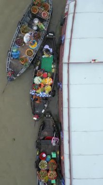 Vietnam 'daki geleneksel yüzen marketin tepeden tırnağa manzarası, tropik meyve, sebze ve yerel ürünlerle dolu renkli teknelerle dolu. Gerçek insanlar, kültür ve günlük yaşam..