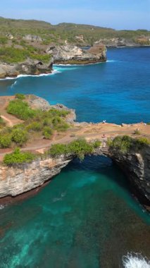 Bali 'de Nusa Penida' daki Broken Beach ve Angels Billabong 'un hava manzarası. Doğal kemer ve turkuaz sulara sahip ünlü kıyı kayaları oluşumu. Seyahat ve doğa temaları için ideal.