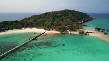 Tahta iskelesi, kristal berrak turkuaz suları, beyaz kum plajı ve yemyeşil yeşilliği olan Koh Kham, Tayland 'ın hava manzarası..
