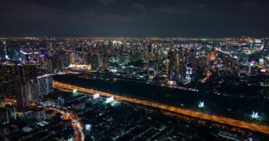 Bangkok, Tayland 'ın gece uçuşları, aydınlık gökdelenler, hareketli şehir silueti ve yoğun karayolu trafiği. Şehir manzarası, hava karardıktan sonra modern metropolü gözler önüne seriyor..