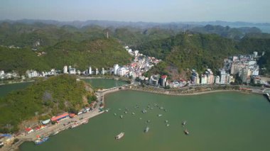 Vietnam 'daki Cat Ba kasabasının liman, kıyı şeridi ve kireçtaşı tepeleri olan insansız hava aracı görüntüsü. Deniz manzaralı, dağlarla çevrili, Lan Ha Bay ve Ha Long Bay 'e açılan bir kapı..