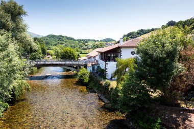 Bask Ülkesi, Fransa 'da kristal berrak dağ nehrinin kıyısındaki bembeyaz ev..