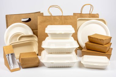 Group shot of biodegradable and recyclable food packaging on white background, paper plates, cups, containers, bags, no logos clipart