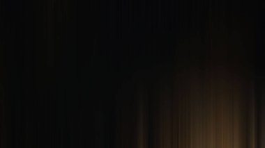 Takım elbiseli ve kravatlı bir adam mikrofonun önünde duruyor.