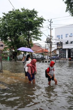 Semarang, Aralık 2022. Birkaç kişi evlerini su bastıktan sonra boşaltmaya hazırlanmak için yiyecek ve giysi dolu çuvallar taşıyor..