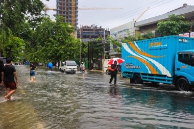 Semarang, Aralık 2022. Bazı insanlar Poncol tren istasyonunu vuran selden geçiyorlar ve bazı sakinler boşaltmaya hazırlanıyorlar. Araçlar sele yakalandı.