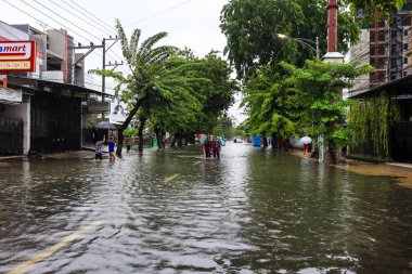 Semarang, Aralık 2022. Bazı insanlar Poncol tren istasyonunu vuran selden geçiyorlar ve bazı sakinler boşaltmaya hazırlanıyorlar. Araçlar sele yakalandı..
