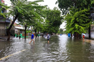 Semarang, Aralık 2022. Bazı insanlar Poncol tren istasyonunu vuran selden geçiyorlar ve bazı sakinler boşaltmaya hazırlanıyorlar. Araçlar sele yakalandı..