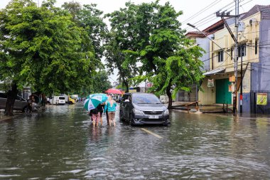 Semarang, Aralık 2022. Bazı insanlar Poncol tren istasyonunu vuran selden geçiyorlar ve bazı sakinler boşaltmaya hazırlanıyorlar. Araçlar sele yakalandı..