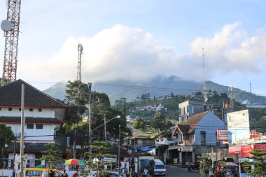 Bandungan Semarang Meydanı 'nın hareketli atmosferi ve arka planda bulutlu bir dağ manzarası.