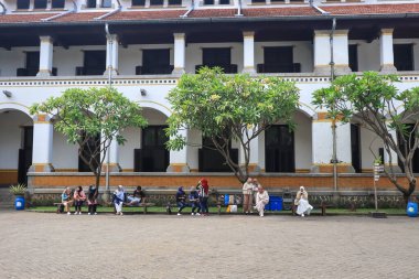 Semarang, December 2022. The atmosphere of the group of tourists together with the tour guide looks at the history of the Lawang Sewu Seribu Pintu building.