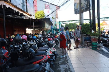 Kudus, December 2022. Photo of a crowded motorbike parking lot in the Kudus city square. Crowded visitors come to the Kudus exhibition