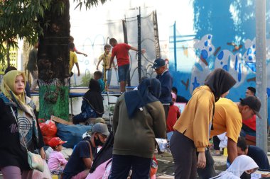 Kudus, December 2022. Photo of food and beverage vendors on the side of the road selling to a crowd of visitors and buyers in the main square of the Kudus city.