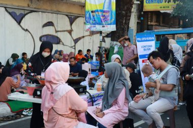 Kudus, December 2022. Photo of food and beverage vendors on the side of the road selling to a crowd of visitors and buyers in the main square of the Kudus city.