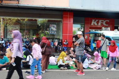 Kudus, December 2022. People on Car Free Day, exercise and relax with family, girlfriends, friends in the town square of Kudus, Indonesia.