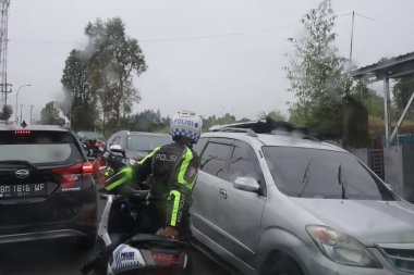 Tegal, Aralık 2022. Kalabalık bir şehir caddesi araba ve diğer ulaşım şekilleriyle dolu. Bu da sürekli bir trafik sıkışıklığı yaratıyor..