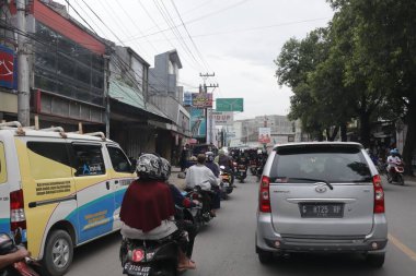 Tegal, Aralık 2022. Kalabalık bir şehir caddesi araba ve diğer ulaşım şekilleriyle dolu. Bu da sürekli bir trafik sıkışıklığı yaratıyor..