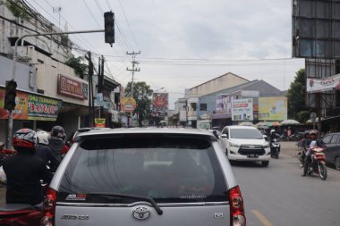 Tegal, Aralık 2022. Kalabalık bir şehir caddesi araba ve diğer ulaşım şekilleriyle dolu. Bu da sürekli bir trafik sıkışıklığı yaratıyor..