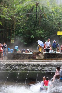 Tegal, Ocak 2023. Meşgul ziyaretçilerin Guci sıcak bahar banyosunun keyfini çıkardıkları bir fotoğraf..