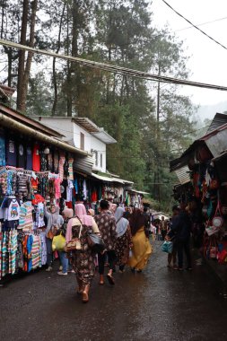 Tegal, Ocak 2023. Guci turist yolunun kenarındaki bir satıcının fotoğrafı. Meyveler, tatlılar, giysiler gibi çeşitli ürünlerin satıldığı hediyelikler için. Alışveriş yapmak isteyen ziyaretçilerle dolu..