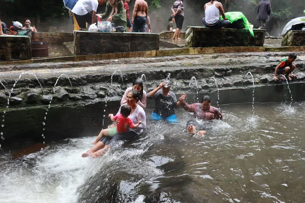 stock image Tegal, January 2023. Photo of busy visitors relaxing and enjoying the Guci hot spring bath.