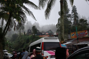 Tegal, Ocak 2023. Guci turist merkezine giderken grup fotoğrafı. Ziyaretçi yoğunluğu, yoğun park araçları ve yol kenarındaki çeşitli satıcılarla..