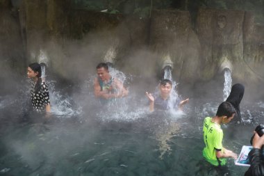 Tegal, Ocak 2023. Meşgul ziyaretçilerin Guci sıcak bahar banyosunun keyfini çıkardıkları bir fotoğraf..