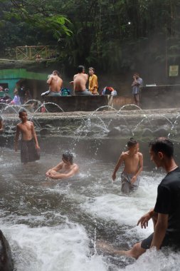 Tegal, Ocak 2023. Meşgul ziyaretçilerin Guci sıcak bahar banyosunun keyfini çıkardıkları bir fotoğraf..