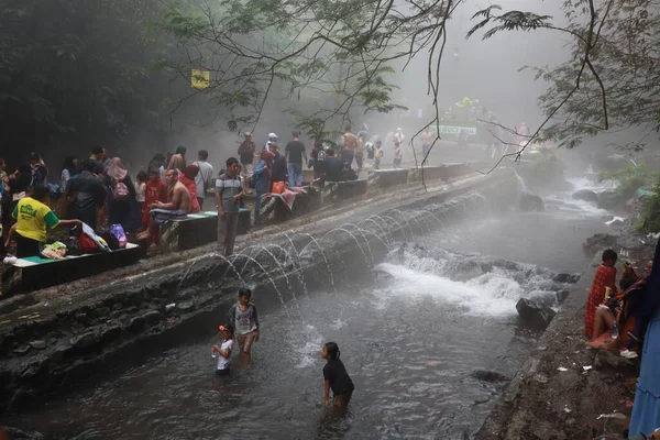 stock image Tegal, January 2023. Photo of busy visitors relaxing and enjoying the Guci hot spring bath.