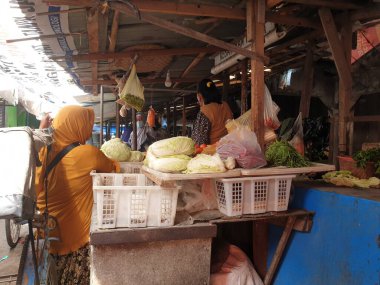 Tegal, Mayıs 2023. Markette müşterilere vermek için bir sebze satıcısının fotoğraf portresi..