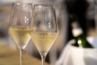 close up of two glasses with white sparkling wine on a table in outdoor restaurant.