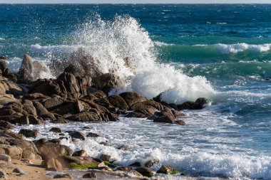 Deniz dalgaları kayalara çarpıyor..