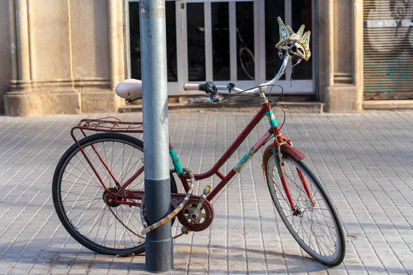 old bicycle with Venetian mask parked in the city, Barcelona.