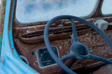 a closeup shot of an old rusty car with a blurred background.