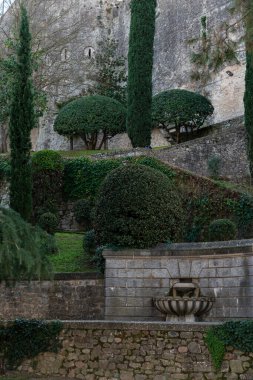 stone wall with ivy and designed plants in the tranquil park in the old city of Girona.