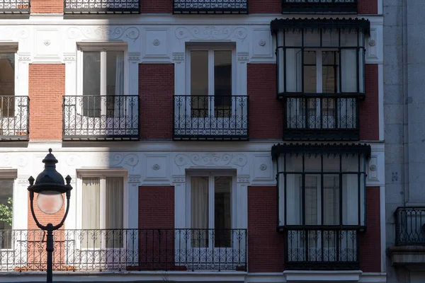 Old Luxury Residential Building with Brick Facade and Balconies view. Malasana district in Madrid, Spain. European Real Estate market, property and maintenance concepts.