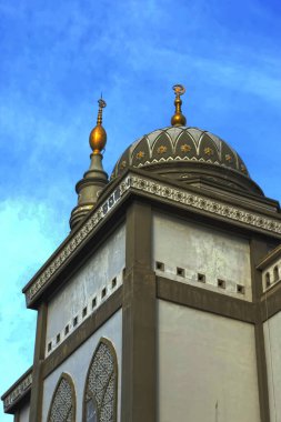 the minaret of the Nurul Fallah mosque in Kubu Raya with a background of blue sky and white clouds