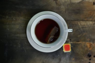 Hot tea in a white cup on a board