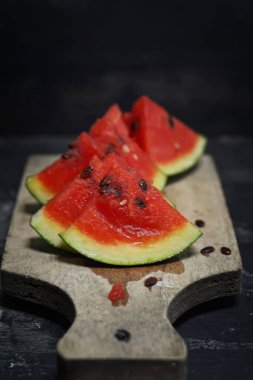 Koyu arkaplanda tahtada taze karpuz meyvesi.