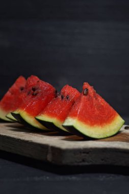 Koyu arkaplanda tahtada taze karpuz meyvesi.