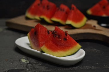 Koyu arkaplanda tahtada taze karpuz meyvesi.