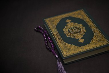 Koyu arkaplanda Kur 'an ve tespih