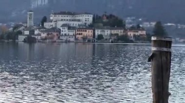 İtalya 'daki Orta Orta Göl kıyısındaki Orta San Giulio adlı küçük bir İtalyan kasabasının güzel manzarası. Sakin sular ve yaz havası. Seyahat ve tatil seyahat tutkusu konsepti.