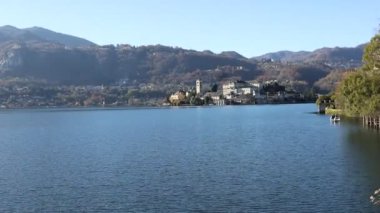 İtalya 'daki Orta Orta Göl kıyısındaki Orta San Giulio adlı küçük bir İtalyan kasabasının güzel manzarası. Sakin sular ve yaz havası. Seyahat ve tatil seyahat tutkusu konsepti.