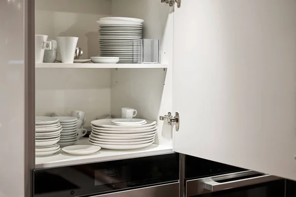 Stock image Glasses, dishes and bowls in a cabinet in a kitchen. Kitchen storage organization. Details of the interior of the kitchen in the house. High quality photo