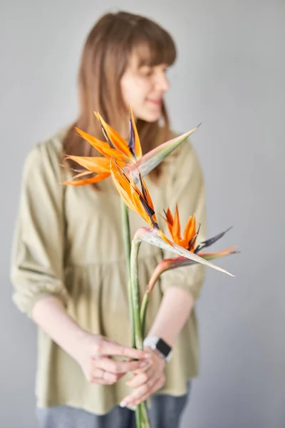 Florist woman creates beautiful bouquet with strelitzia. European floral shop concept. Handsome fresh bunch. Education, master class and floristry courses. Flowers delivery. High quality photo